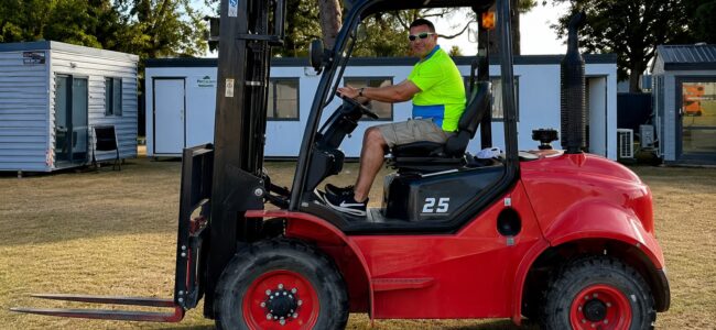 Side view of a rough terrain forklift supplied by Dench Forklifts in Christchurch, featuring large off-road tyres and high ground clearance.